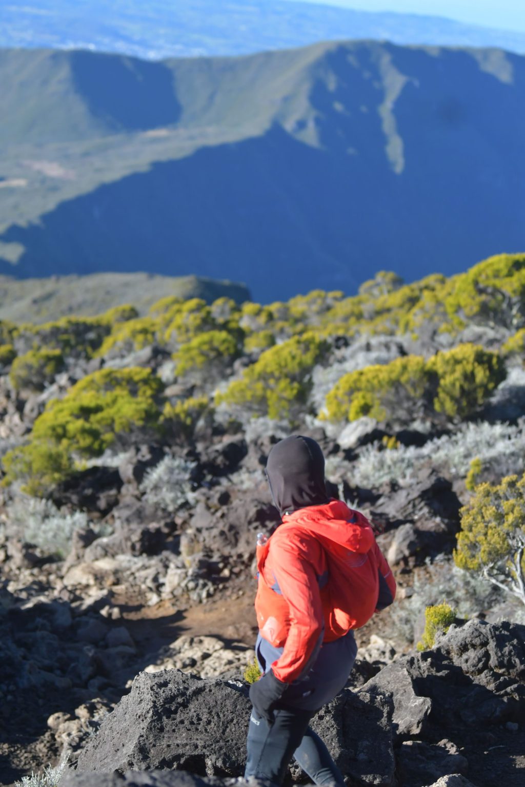 Coureuse en veste rouge sur un sentier de montagne