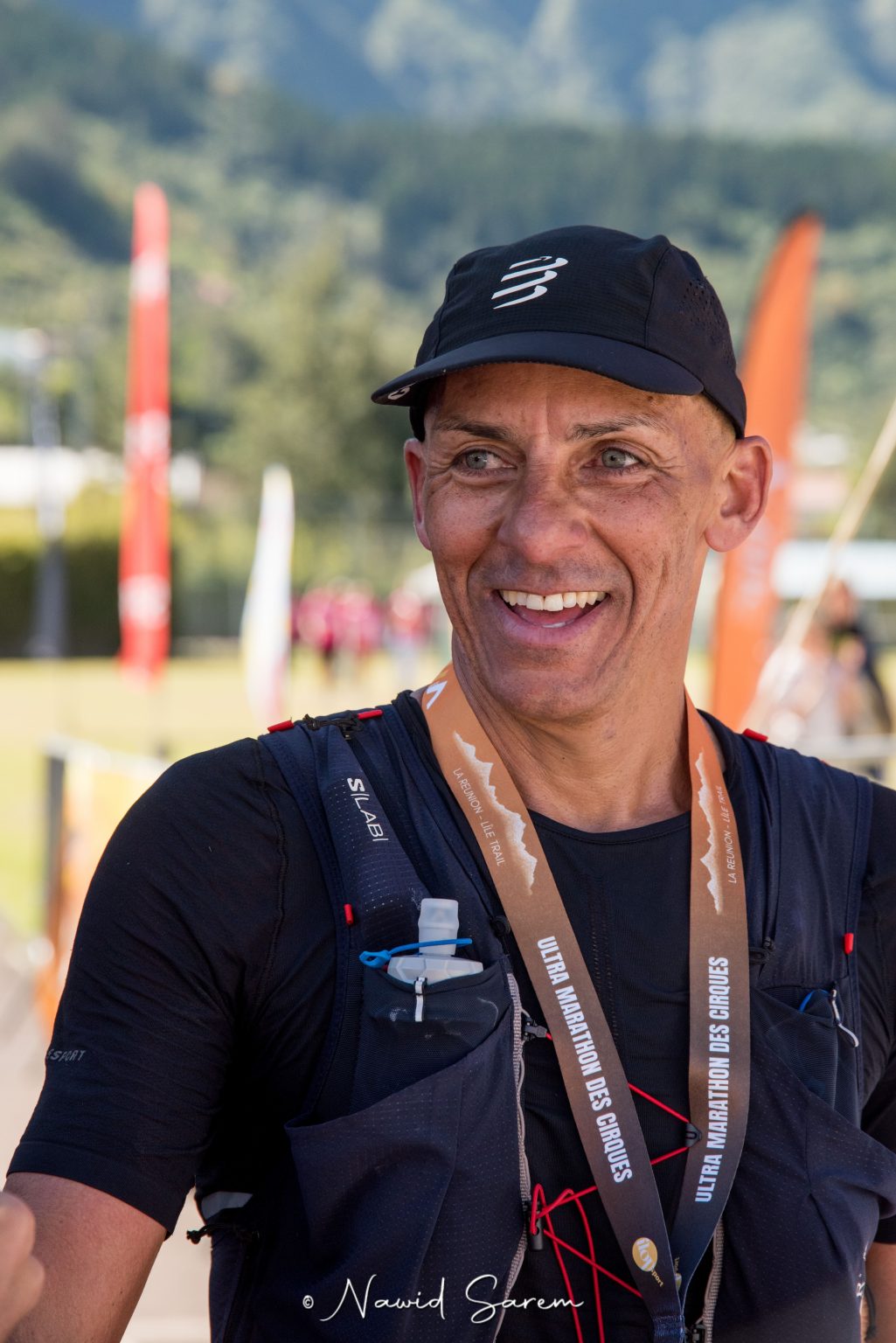 Coureur finisher souriant, sac de trail sur le dos